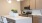 a kitchen with a white counter top and a white pot with yellow flowers